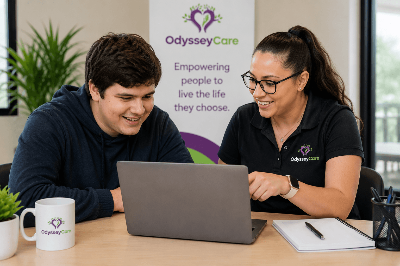 OdysseyCare team member supporting a young person with a laptop